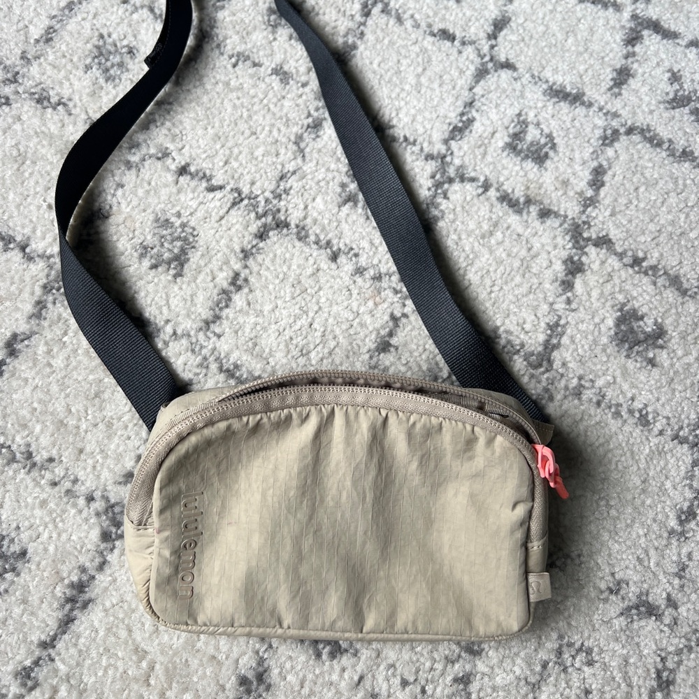 Lululemon mini belt bag. Lightly used. Light tan color. Pink lipgloss mark